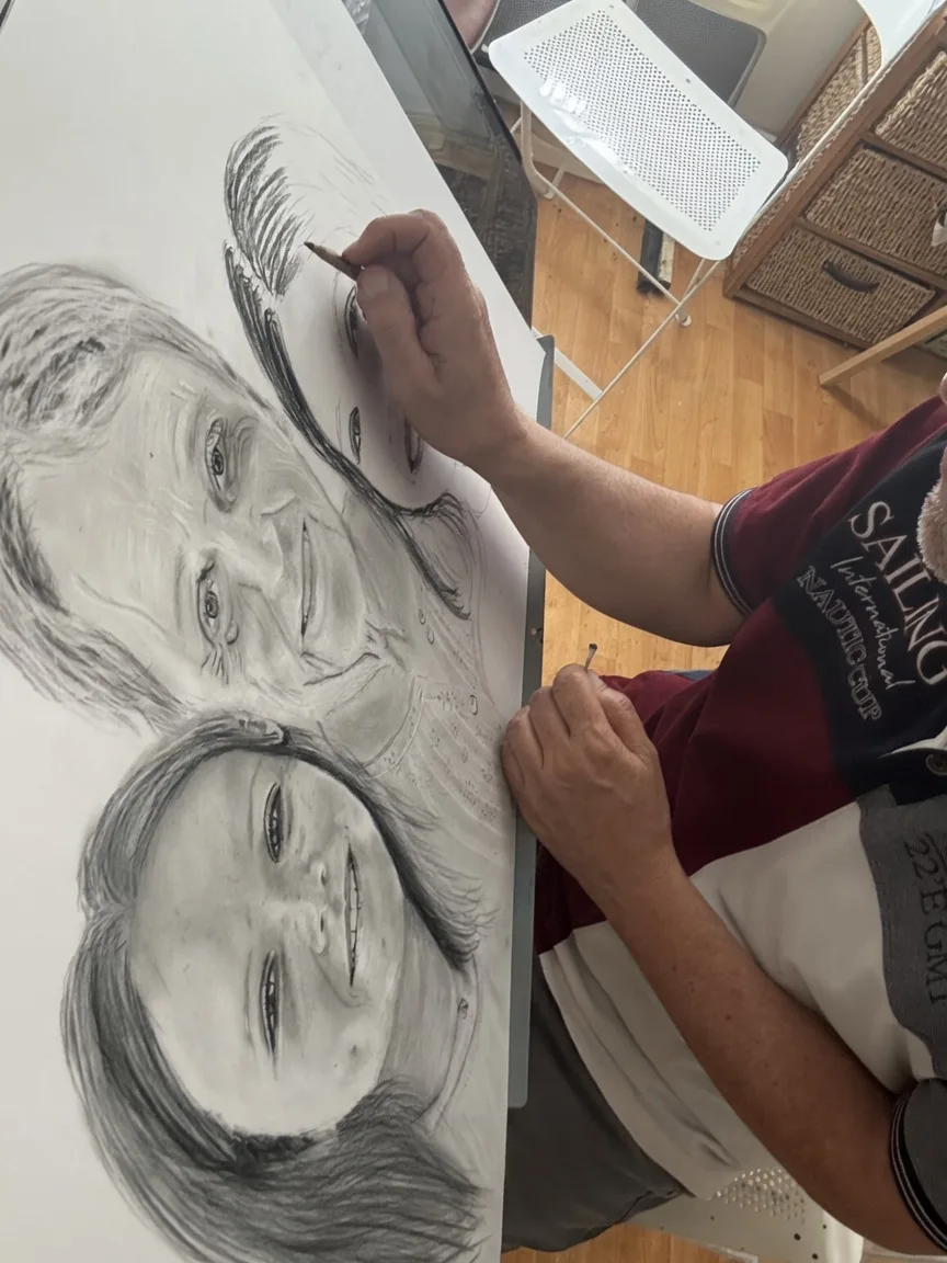 Double portrait au crayon en cours de réalisation, la main de l'artiste travaillant un regard